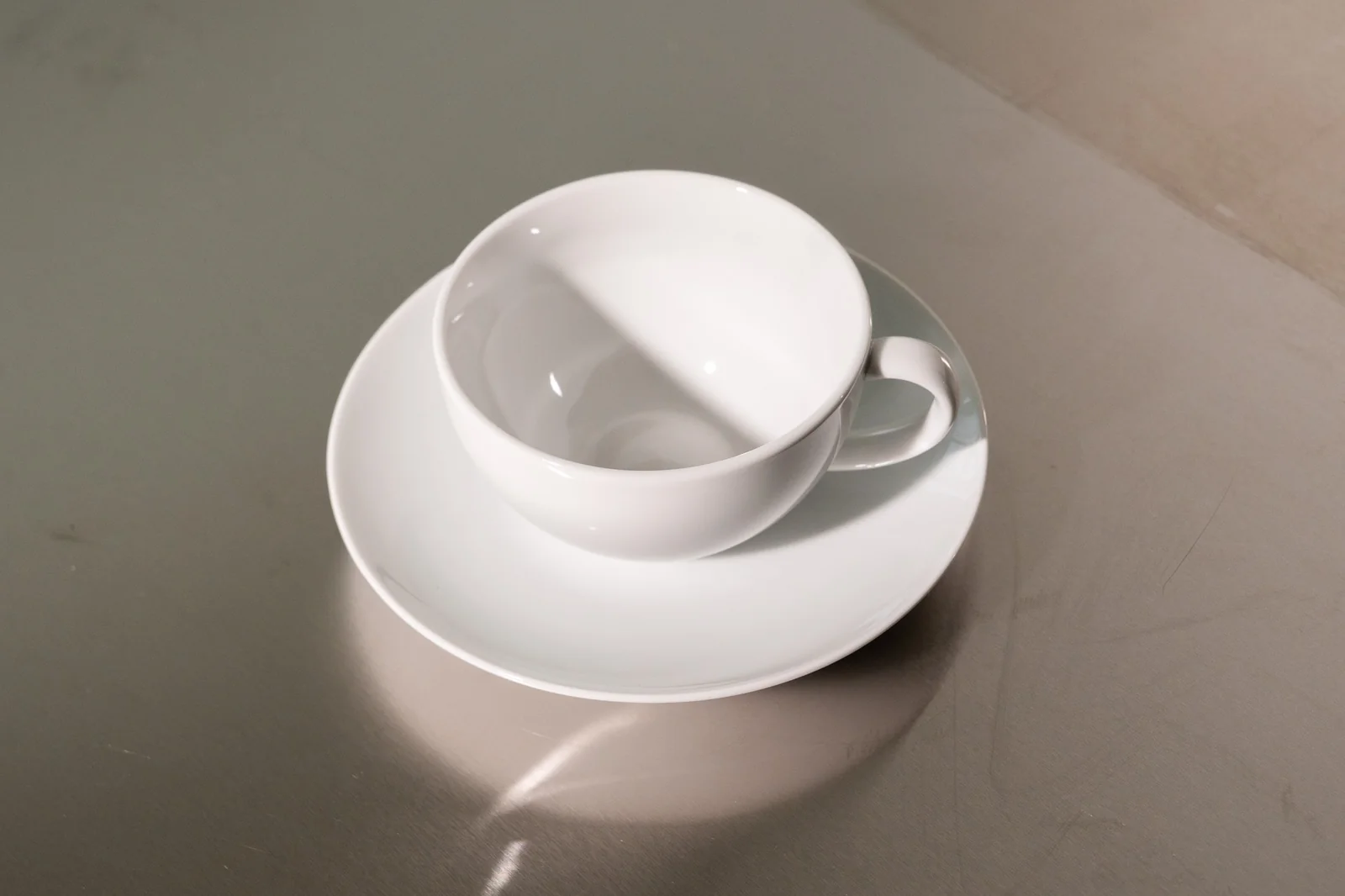 Weiße bauchige Delta-Cappuccinotasse mit passender Untertasse.